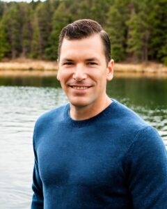 Neil in a long sleeve blue shirt at a lake house explaining: How To Report A Fake Review On Google – Here's What to Do!